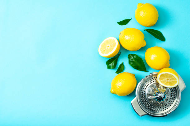 istock Ripe lemons flat lay with leaves on blue background 1213834576