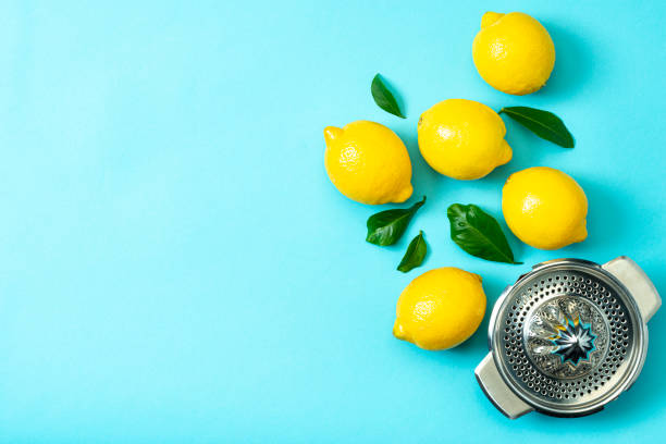 istock Ripe lemons flat lay with leaves on blue background 1213834615