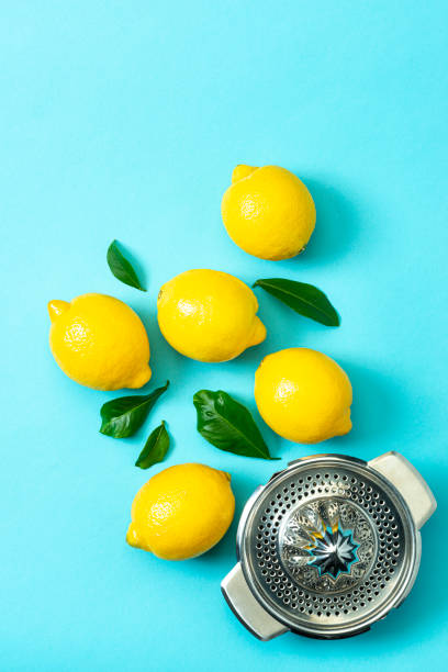 istock Ripe lemons flat lay with leaves on blue background 1213834650