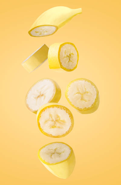 Falling banana fruits isolated on yellow background.