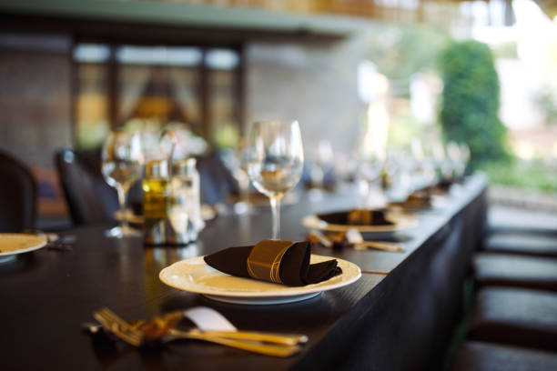 istock Wedding table served with cutlery, serviette, crockery and covered with a white tablecloth in restaurant. 1213836690