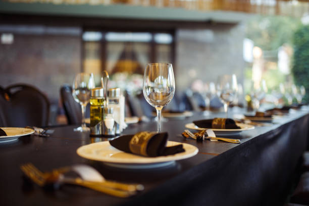 istock Wedding table served with cutlery, serviette, crockery and covered with a white tablecloth in restaurant. 1213836695