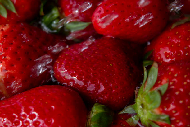 heap of strawberries in water with bubbles