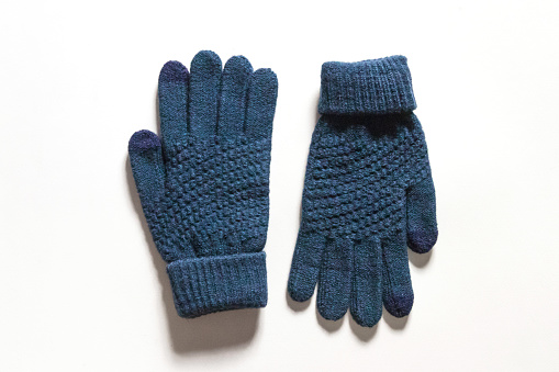 Dark blue knitted touch screen gloves isolated on white background.