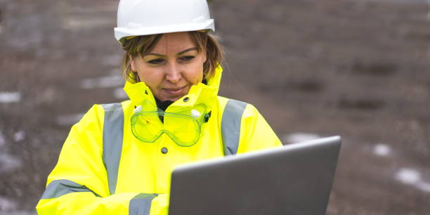 woman civil engineer close up. young woman using laptop on construction site. woman engineer developer holding laptop working confident outdoors in construction site. woman architect inspecting site. civil engineer at construction site is inspecting site. - female construction telephone building contractor imagens e fotografias de stock