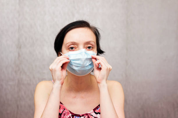 istock Woman with a protective medical mask on her face. 1213842550