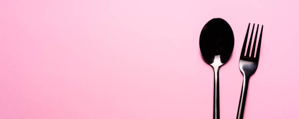 istock Metal Spoon and fork Isolated on pink background 1213845750