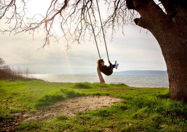 istock Woman is swinging near coast. 1213848080