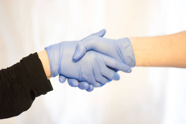 istock shaking hands with gloves for stop corona virus outbreak. Selective focus. Coronavirus and epidemic virus symptoms. 1213852185