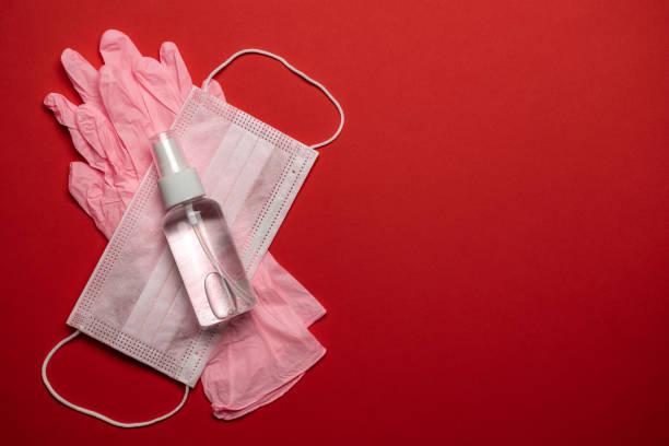 sanitizer bottle, medical surgical mask and lab gloves - virus protection equipment on red background. covid middle east respiratory syndrome coronavirus. corona virus disease 2019, covid-19 - antibiotic red medicine healthcare and medicine imagens e fotografias de stock