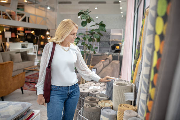 istock Woman standing in front of carpets looking with interest. 1213853864