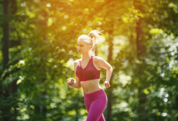 istock Young woman running in the woods. 1213854119