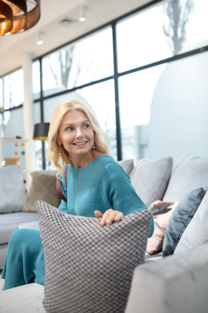 istock Joyful woman on the couch holding a pillow. 1213854222