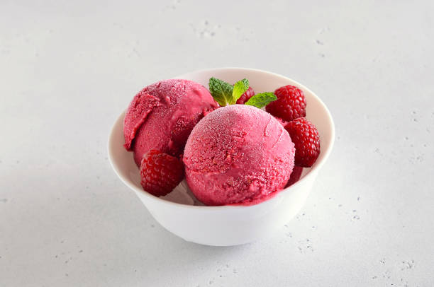istock Raspberry ice cream scoop with fresh raspberries in bowl 1213855234