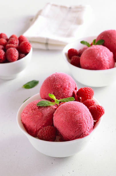 istock Raspberry ice cream scoop with fresh raspberries in bowl 1213855291