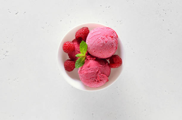 istock Raspberry ice cream scoop with fresh raspberries in bowl 1213855297