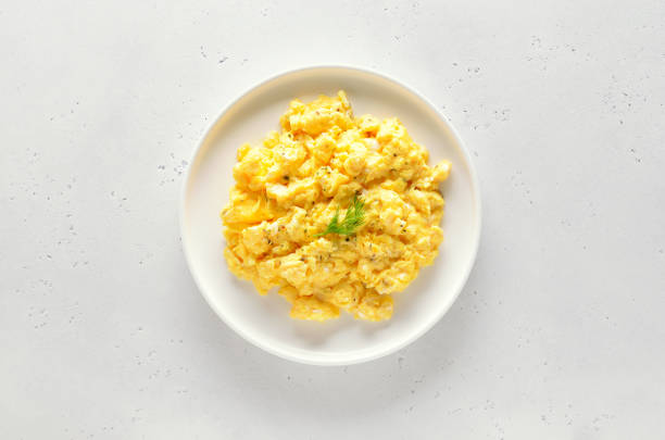 Scrambled eggs on plate over white stone background stock photo