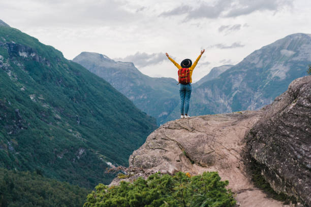 istock Woman with hands up standing  in mountains in Norway 1213862634