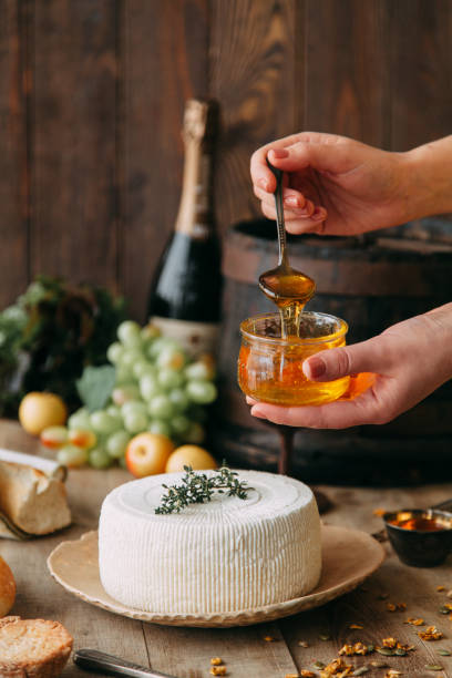 istock Curd cheese is watered with honey. The chef's hands prepare cheese. A large white round cheese on a plate. 1213866020