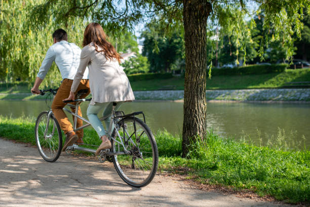 istock Caucasian couple riding a tandem bicycle on a river bank 1213868643