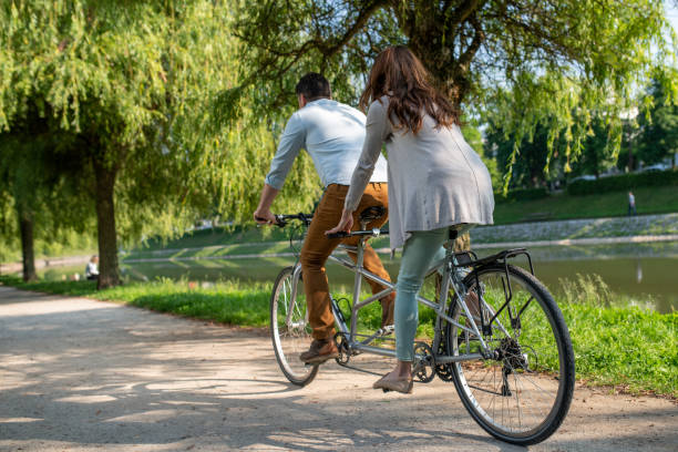 istock Couple riding a tandem bicycle on a river bank 1213868655