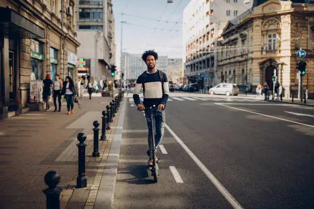 Young man ridding electric scooter