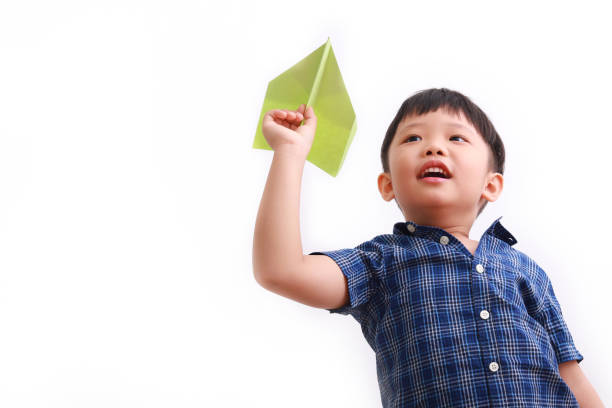 Little girl running in the park with a paper plane in her hand, heading toward her mom, reflecting the pure joy of childhood and the freedom of exploring the outdoors. Her mom watches with a loving smile, eagerly awaiting the moment to wrap her daughter in a warm hug