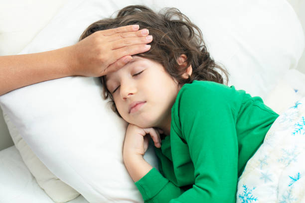 istock Mother checking on sick her son laying in bed 1213870168