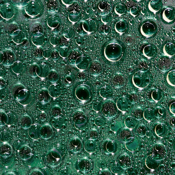 istock Green transparent spheres of different diameters and their reflections are randomly located on a black background. Space abstraction. 1213872870