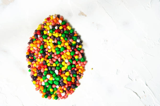 Easter egg shape made of rainbow colored candy. Flat lay