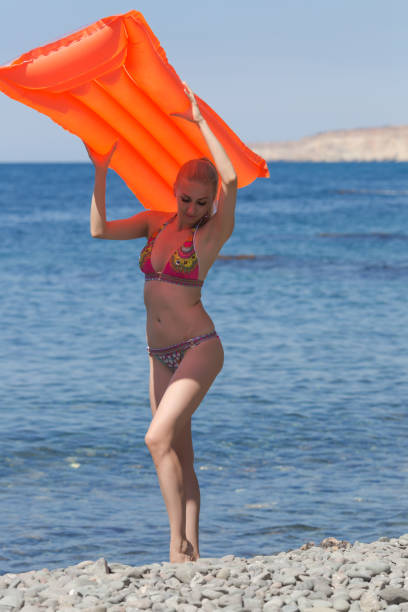istock Slim young woman resting on wild shingle beach 1213873934