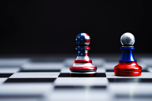 EE.UU. y Rusia bandera de la pantalla de impresión en el ajedrez de peón con fondo negro. Es símbolo de la barrera fiscal de la guerra del comercio arancelario entre los Estados Unidos de América y Rusia.-Imagen. photo