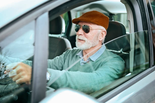 uomo anziano con occhiali da sole seduti in auto alla guida - driving text messaging accident danger foto e immagini stock