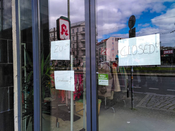 Closed doors at a shop in Berlin, Germany, during coronavirus shutdown Signs reading "closed" in german and english on the closed doors of a vintage clothes shop in the Friedrichshain district of Berlin, Germany, during coronavirus shutdown. walking into glass door stock pictures, royalty-free photos & images