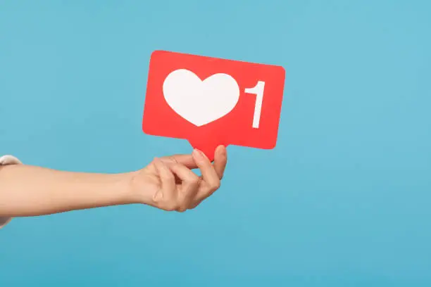 Photo of Appreciate content with heart button. Closeup of hand holding like icon of social media, emoji sign