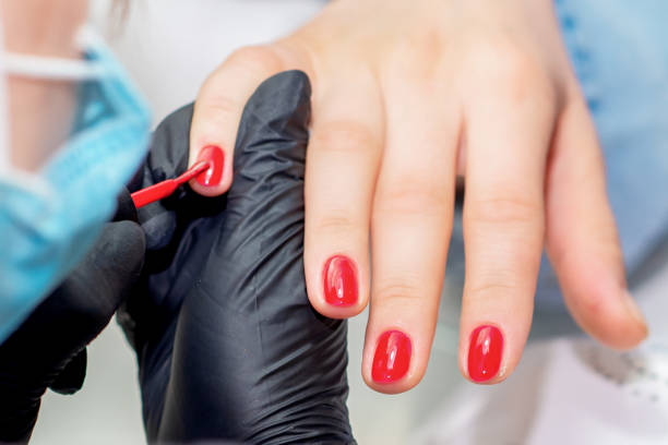 istock Manicurist paints nails. 1213881110