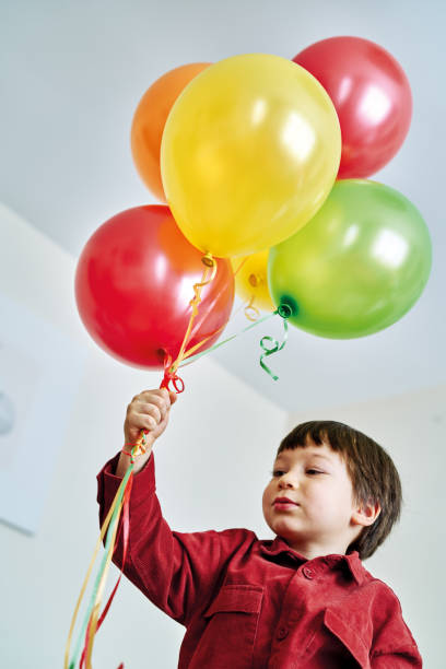istock Cute child playing colorful hellium balloons at home. 1213881197