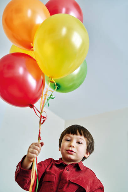 istock Cute child playing colorful hellium balloons at home. 1213882013