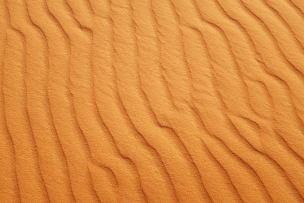istock Bright saturated orange color desert sand wave patterns for a warm summer background. 1213886523