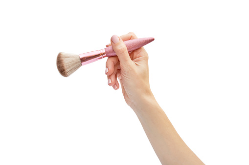 Woman's hand holding brush for makeup. Isolated on white.