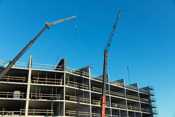 istock housing development - workers and cranes working on apartment building construction site 1213890978