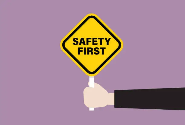 Vector illustration of The human hand holds a safety first signage