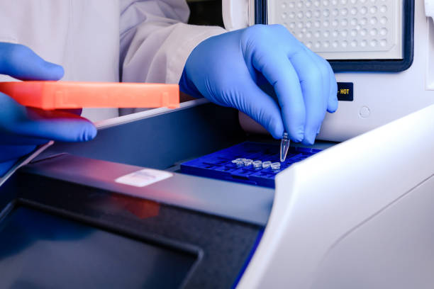 loading a dna tube into a pcr (polymerase chain reaction) thermocycler machine in a bioscience laboratory. concept of science, laboratory and study of diseases. coronavirus (covid-19) treatment developing. - pcr device imagens e fotografias de stock