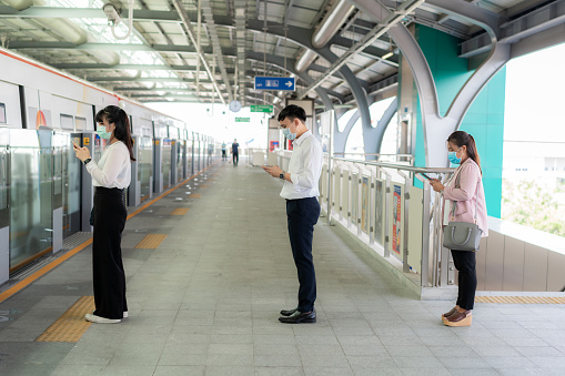 Three Asian people wearing mask standing distance of 1 meter from other people keep distance protect from COVID-19 viruses and people social distancing  for infection risk and disease prevention measures.