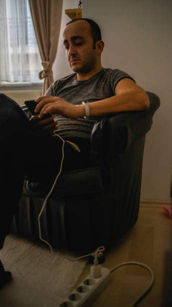 istock bald man writes on the phone with the charge 1213898415