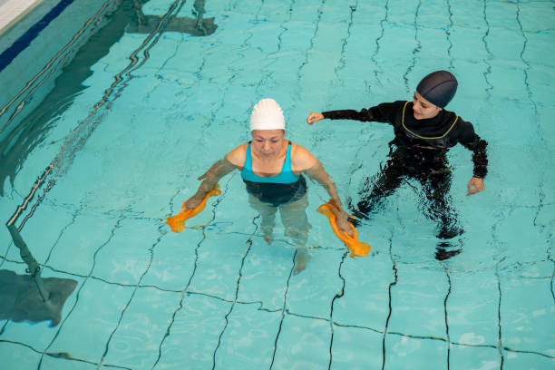 istock Patient exercising in a swimming pool with a physiotherapist 1213902565