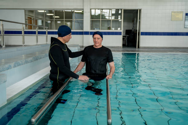 istock Elderly man in physical therapy in the swimming pool 1213902579