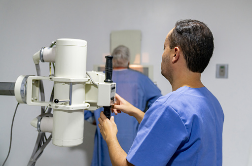 Radiologist at the hospital taking an x-ray for a senior patient - healthcare and medicine