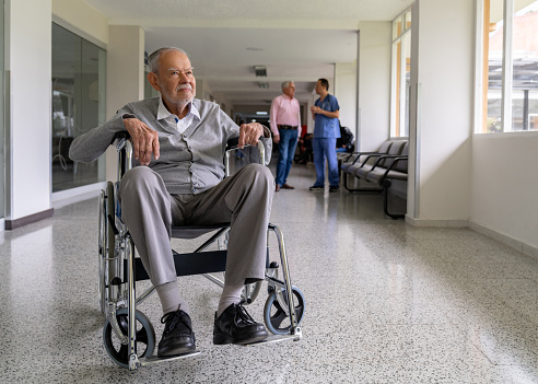 Disabled senior man at the hospital in a wheelchair - healthcae and medicine concepts