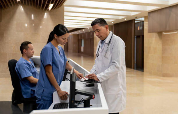 Doctor talking to a nurse in the reception at the hospital Doctor talking to a nurse in the reception at the hospital - medical concepts triage stock pictures, royalty-free photos & images